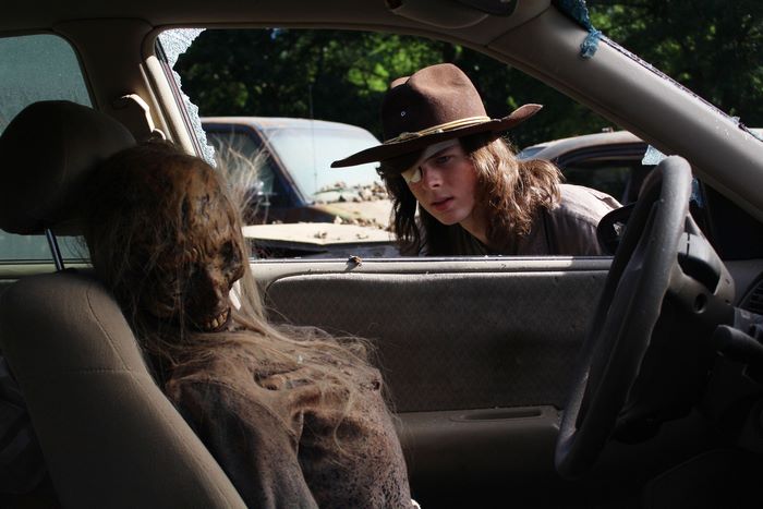 Carl Grimes from The Walking Dead in a car with a walker