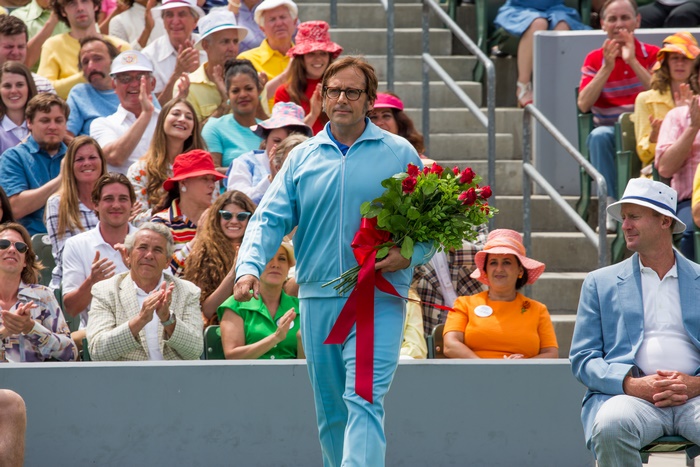 Steve Carell in a blue tracksuit holding roses