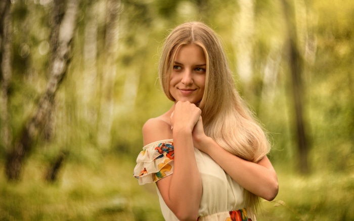 Young woman with blonde hair in a dress outdoors