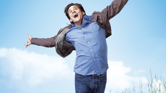 Jim Carrey jumping against a blue sky