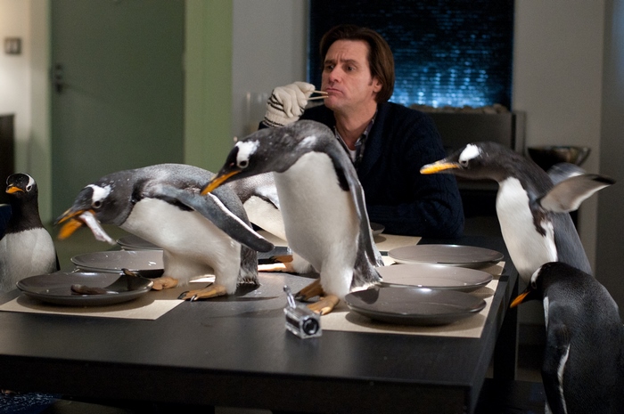 Jim Carrey with penguins at a table