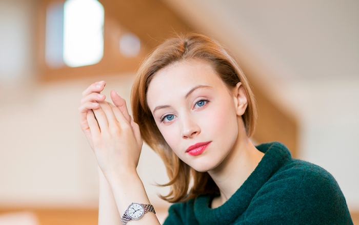 Sarah Gadon wearing a green sweater and watch