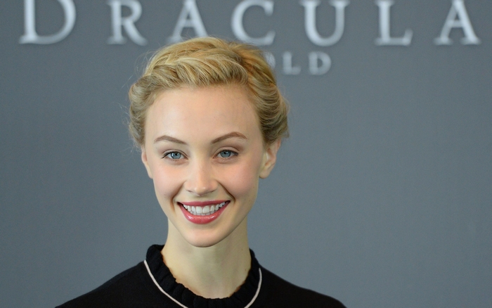 Sarah Gadon in front of Dracula Untold logo