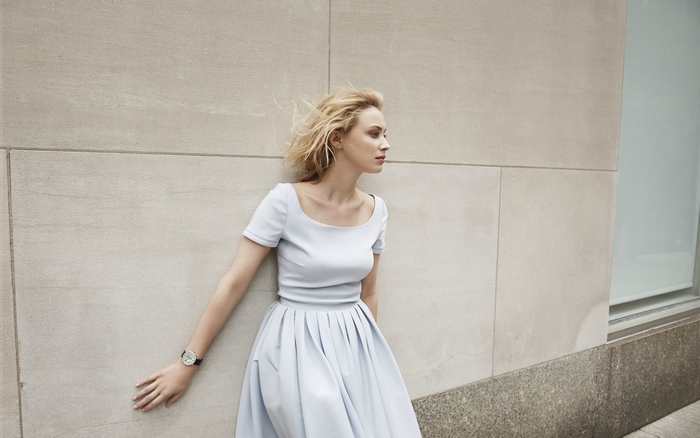 Sarah Gadon leaning against a stone wall