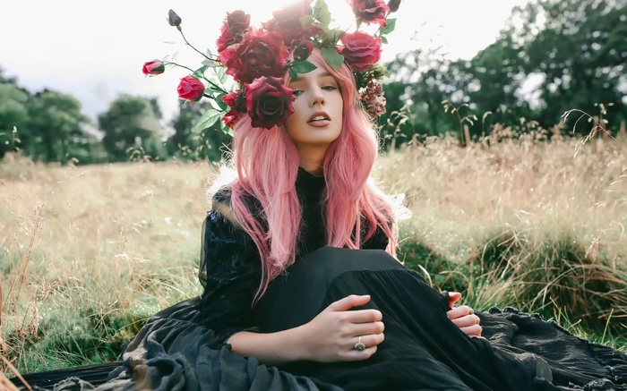 Woman with pink hair and flower crown in a field