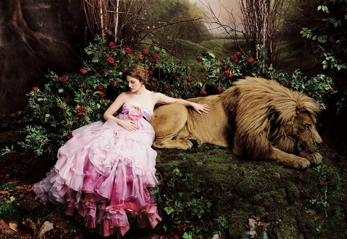 Drew Barrymore with a lion in a garden