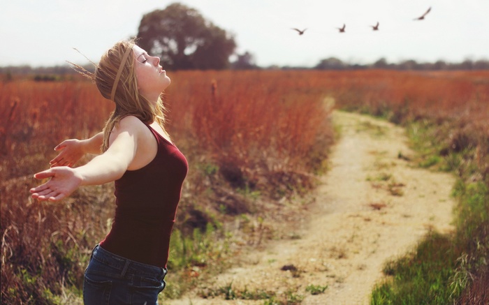 Woman with arms outstretched in a field