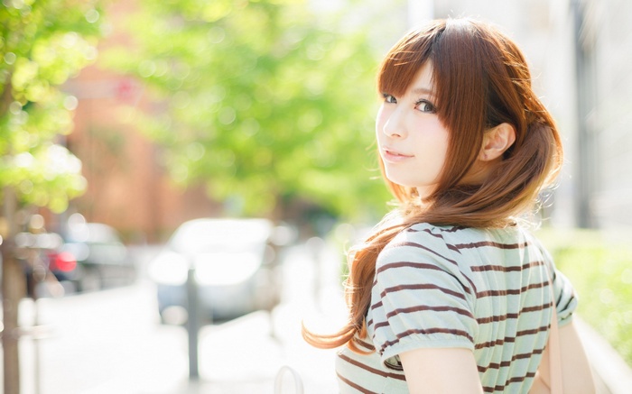 Young woman with brown hair looking over her shoulder