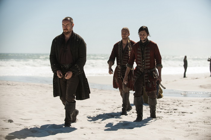 Toby Stephens and two men on a beach