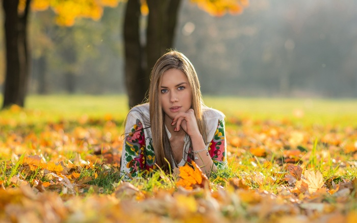Woman lying in autumn leaves