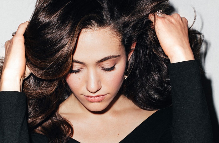 Emmy Rossum with her hands in her hair