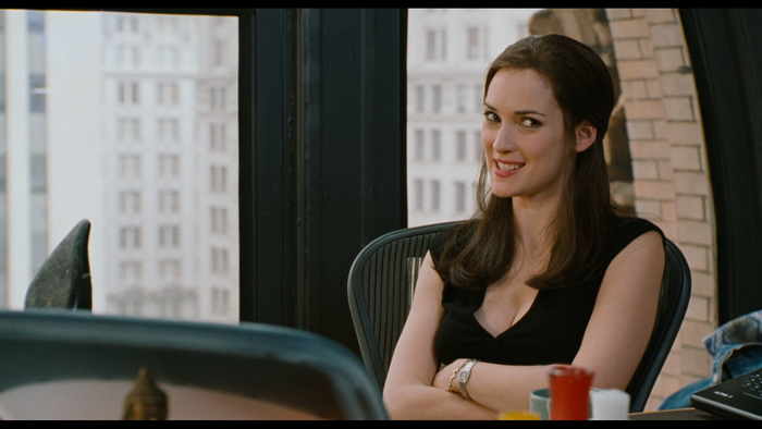 Winona Ryder sitting at a desk