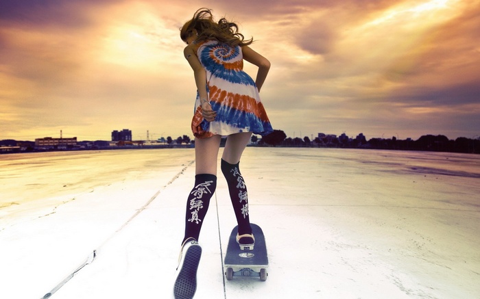 Woman on skateboard at sunset
