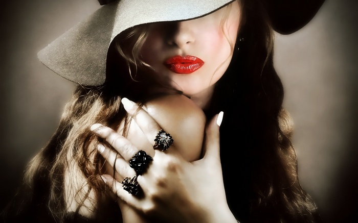 Woman in a wide-brimmed hat with red lipstick and rings