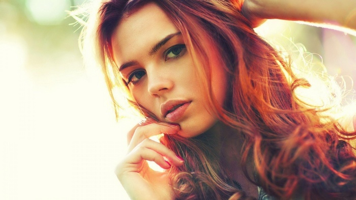 Woman with red hair in sunlight