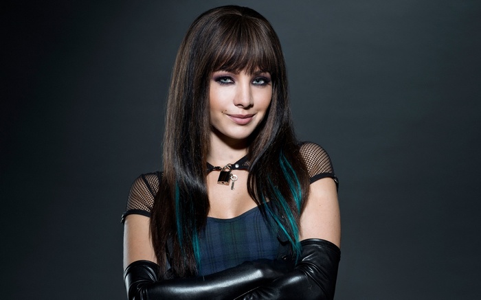 Woman with dark hair and blue streaks wearing leather gloves