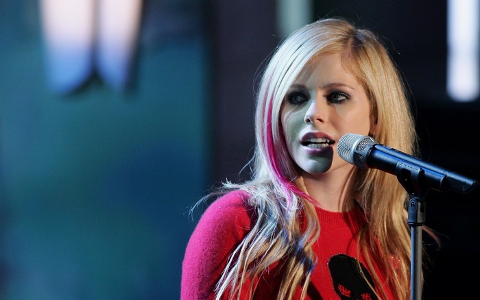 Avril Lavigne singing into a microphone