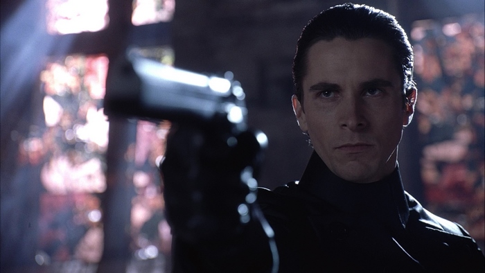 Christian Bale holding a gun