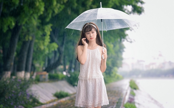 Young woman holding an umbrella in the rain