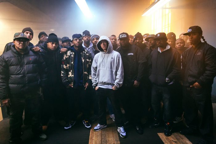 Eminem and his crew in a dimly lit room