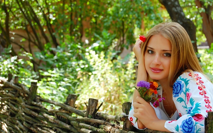 Woman in embroidered shirt holding flowers