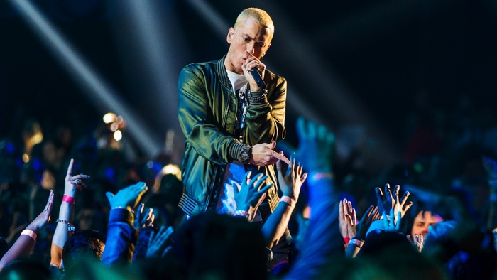 Eminem performing on stage with a crowd