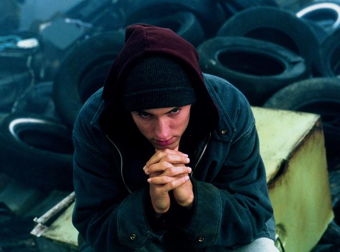 Eminem in a dark setting with tires