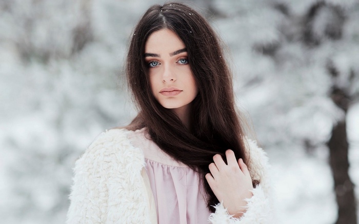 Woman with blue eyes in a snowy forest
