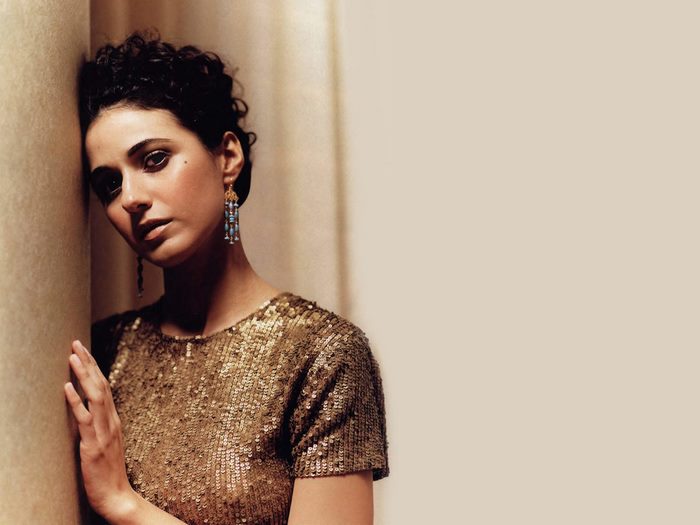 Emmanuelle Chriqui leaning against a wall