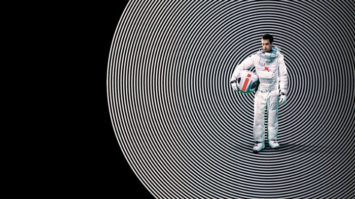 Sam Rockwell in an astronaut suit holding a helmet
