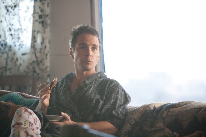 Sam Rockwell in a bathrobe eating