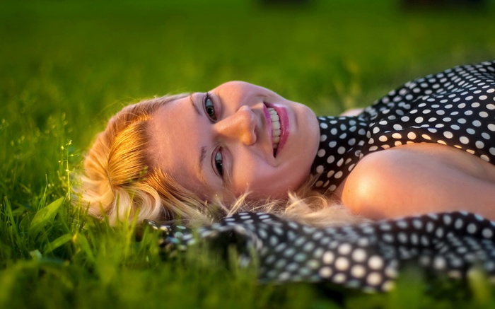 Woman lying on grass in a polka dot dress