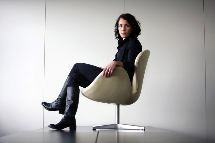 Noomi Rapace sitting in a chair