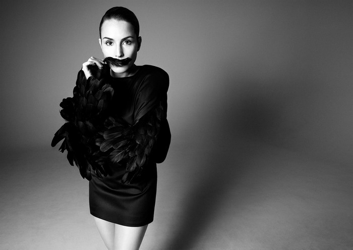 Noomi Rapace in black dress with feather sleeves
