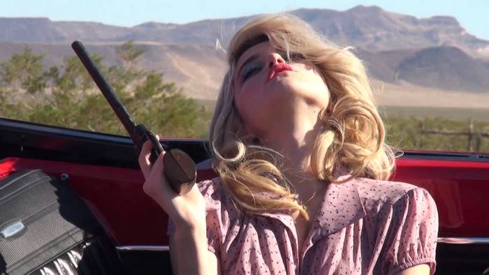 Sky Ferreira with a gun in a car