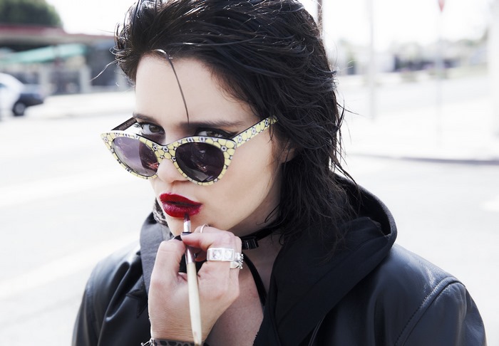 Sky Ferreira applying lipstick