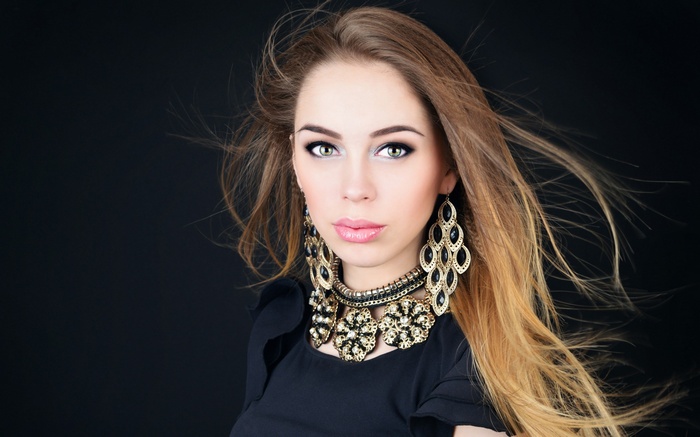 Woman with elaborate jewelry and windblown hair