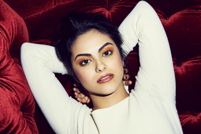 Camila Mendes on a red couch