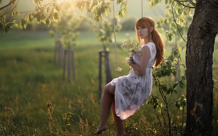 Woman on a swing holding flowers