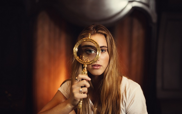 Woman looking through a magnifying glass