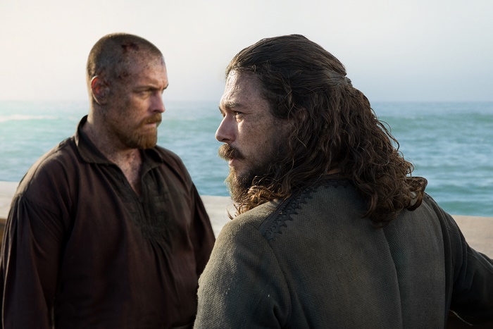 Two men on a pier by the sea