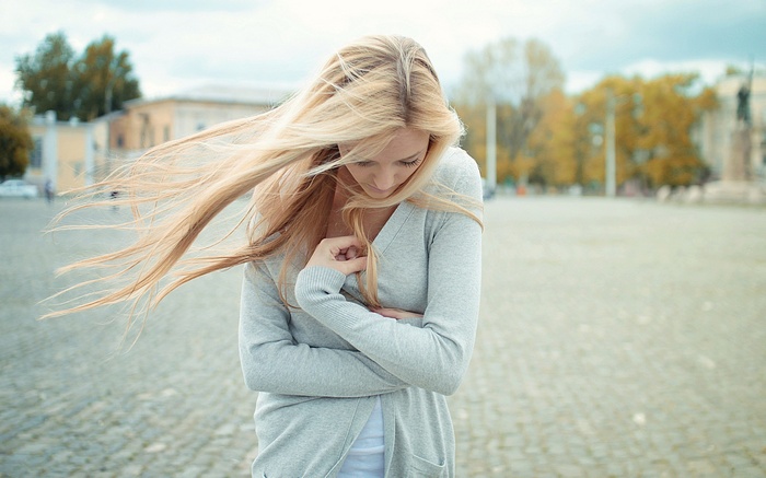 Woman with blonde hair in a grey cardigan