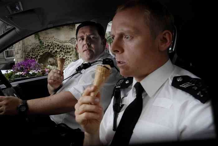 Two police officers eating ice cream cones in a car