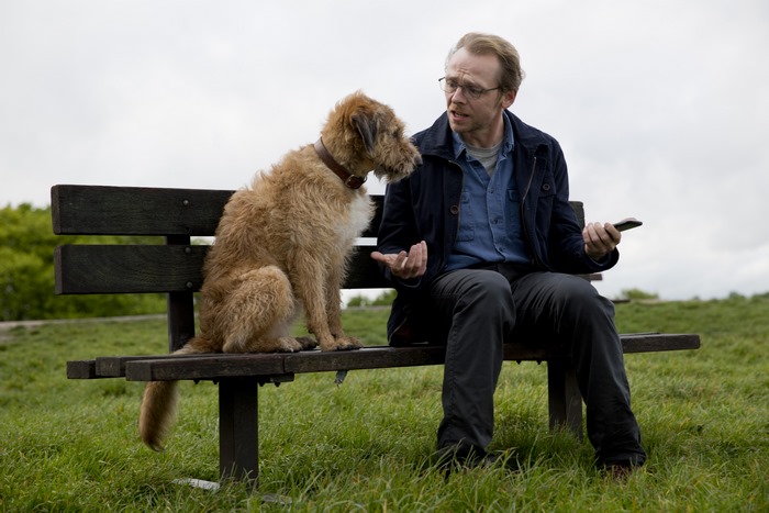 Simon Pegg with a dog on a bench