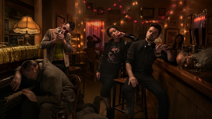 Joseph Gilgun and others in a dimly lit bar