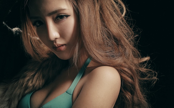 Woman with long brown hair and teal top