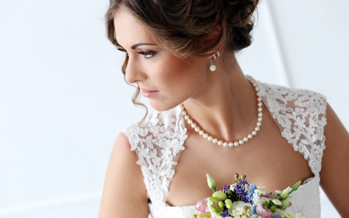Bride wearing pearl necklace and lace dress
