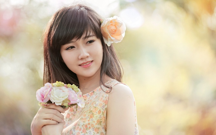 Young woman with flowers in hair and hand
