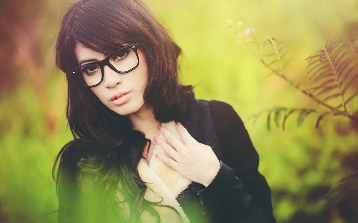 Woman wearing glasses and a vest outdoors