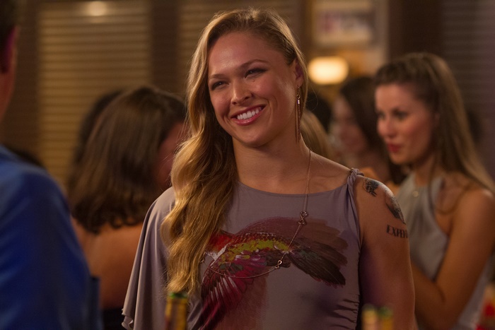 Ronda Rousey in a purple dress with a bird print